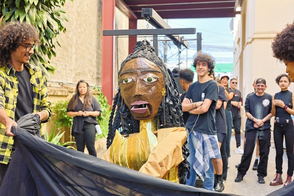 Cortejo pelas ruas do Brás com a boneca gigante feita pelos alunos de Técnicas de Palco, na sede Brás da SP Escola de Teatro. (10/06/2024). | Foto: Clara Silva.