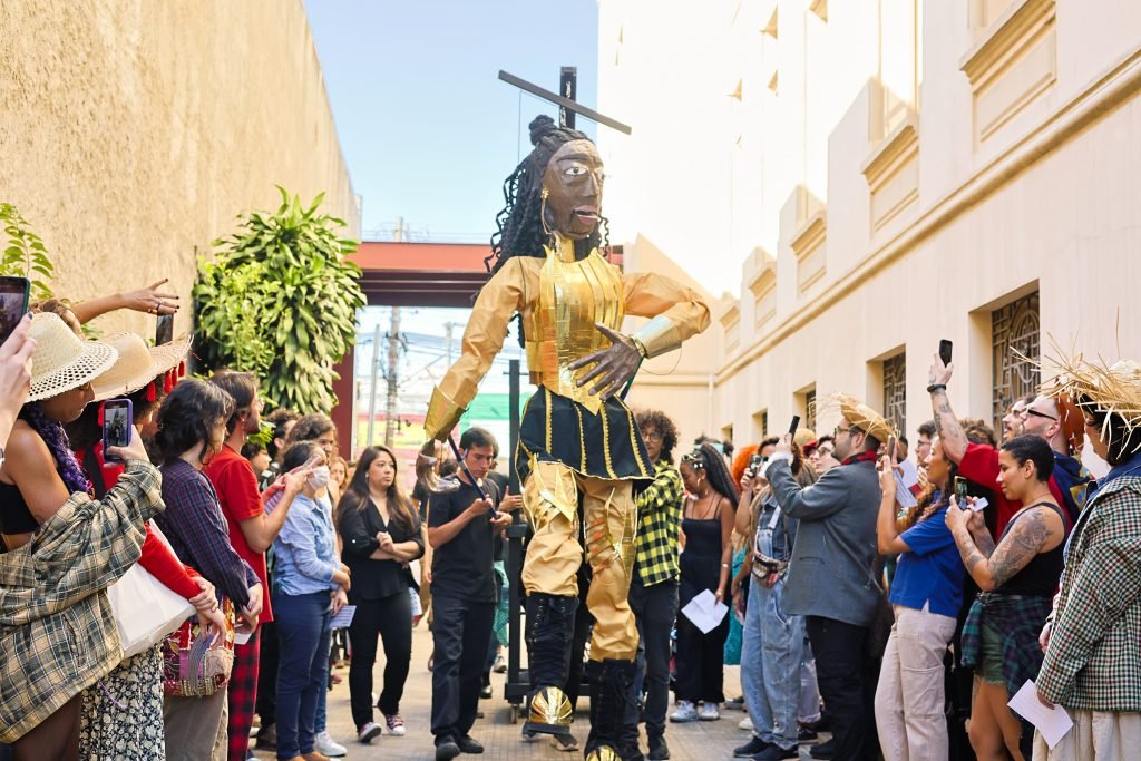 Cortejo pelas ruas do Brás com a boneca gigante feita pelos alunos de Técnicas de Palco, na sede Brás da SP Escola de Teatro. (10/06/2024). | Foto: Clara Silva.