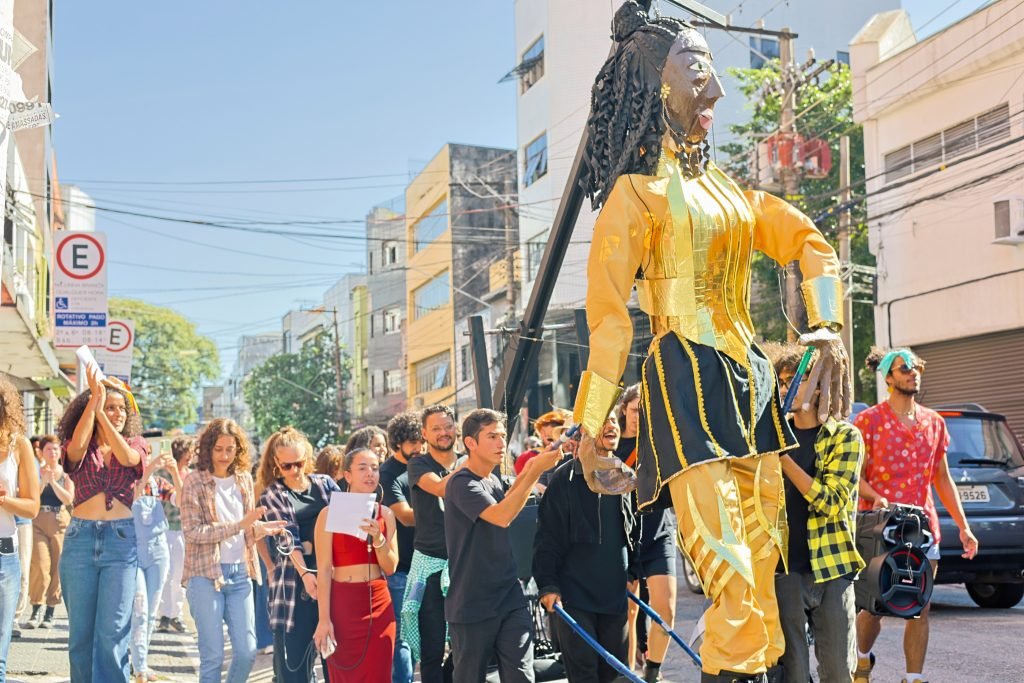 Cortejo pelas ruas do Brás com a boneca gigante feita pelos alunos de Técnicas de Palco, na sede Brás da SP Escola de Teatro. (10/06/2024). | Foto: Clara Silva.